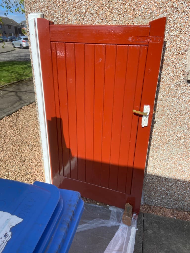 Bold red garden gate with crisp cream trim