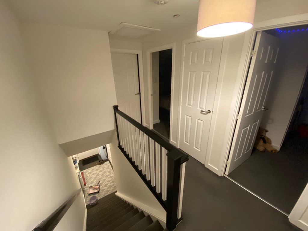 Crisp white interior stairs and landing freshly repainted, ready for new tenants